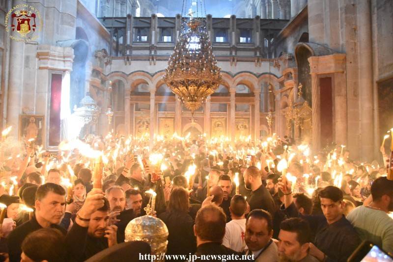 Το Αγιον Φως μεταδίδεται σε όλους τούς πιστούς στο Ναό.